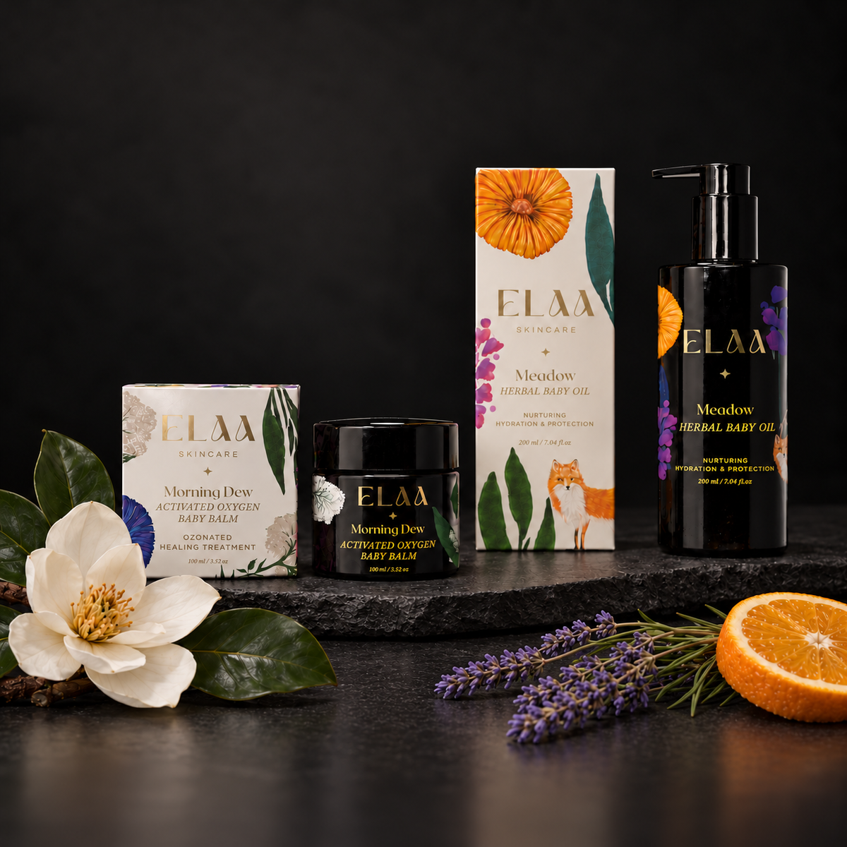 ELAA Baby collection arranged on dark slate with softly lit packaging