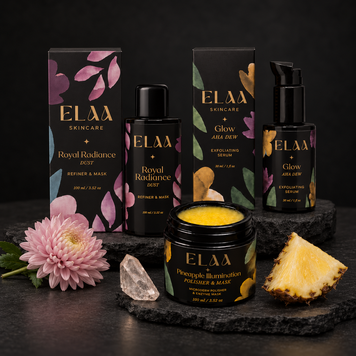 ELAA Exfoliants collection arranged on dark slate with softly lit packaging