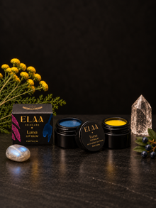 ELAA Luna Lip Balm with botanicals on a flat dark surface