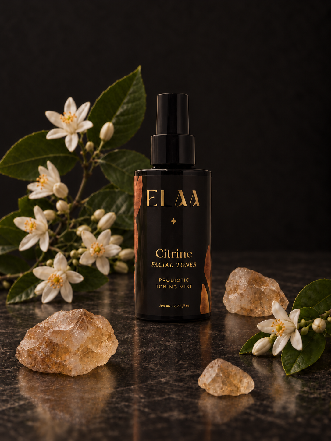 ELAA Citrine Probiotic Toning Mist with neroli blossoms and citrine crystals in soft light on dark stone