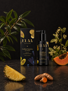 ELAA Golden Sunrise cleanser and carton with botanicals and fruit on a flat dark surface