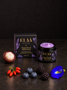 ELAA Superfood Dream Cream with purple cream, carton and berries on a flat dark surface