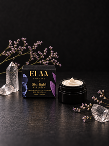 ELAA Starlight eye cream and carton with flowers and crystals on a flat dark surface