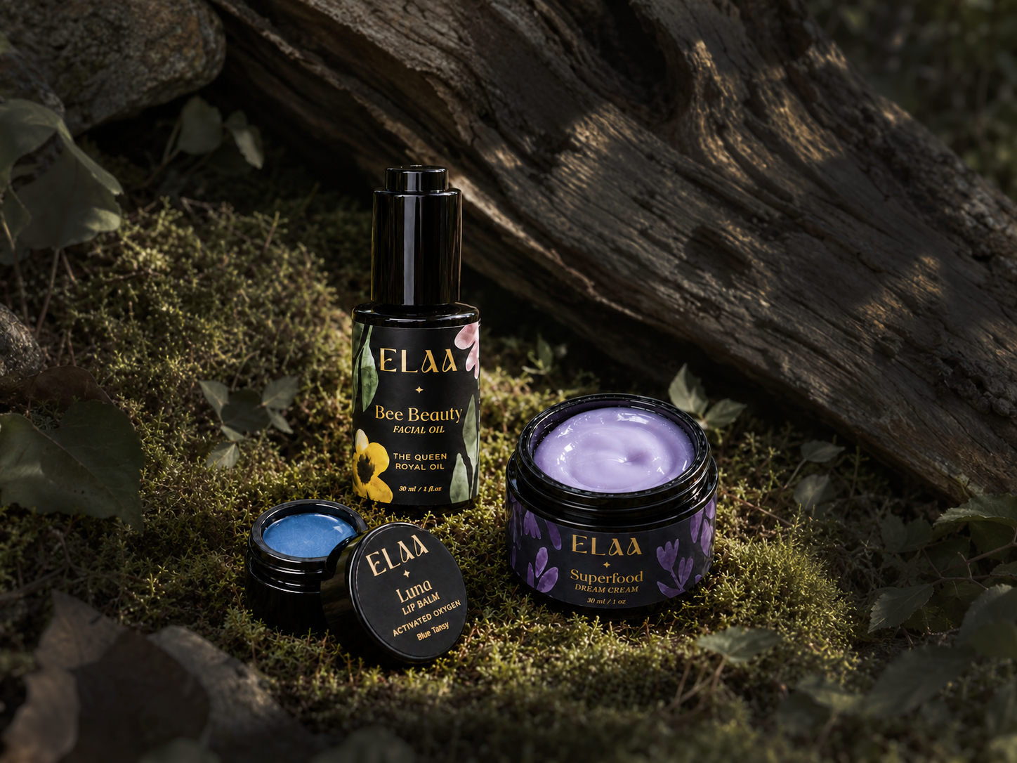 Bee Beauty facial oil, Luna lip balm and Superfood Dream Cream nestled in moss beneath weathered wood.